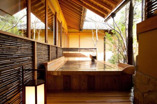 un bain à remous japonais dans un bâtiment en bois dans l'établissement Yufuin Santoukan, à Yufu