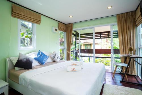 a bedroom with a large white bed and a balcony at Hill Zone Home Stay by Little Paradise in Haad Rin