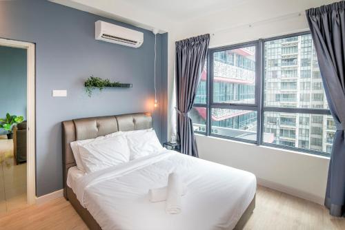 ein Schlafzimmer mit einem weißen Bett und einem großen Fenster in der Unterkunft KL Arte Plus @ Jalan Ampang by IdealHub in Kuala Lumpur