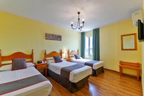 a hotel room with two beds and a chandelier at Hotel Mavi in La Cabrera