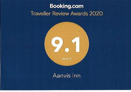 a sign that reads travel review awards with a yellow circle at Aanvis inn in Ooty