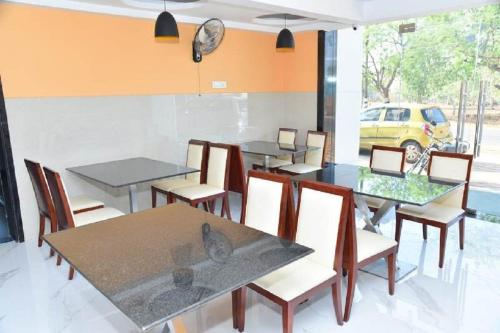 a dining room with tables and chairs and a yellow car at Ganesh Meridian in Tiruppattūr