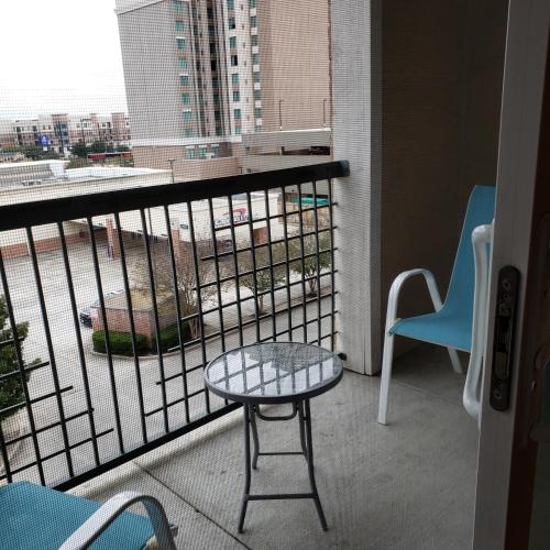 a table and chair on a balcony with a view at Domain at Kirby in Houston