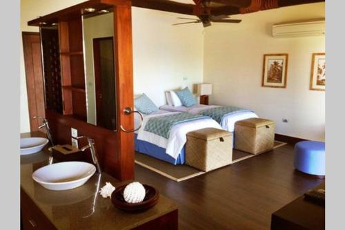 a bedroom with a bed and a bathroom with a sink at Villa Takali - CFC Certified in Pacific Harbour