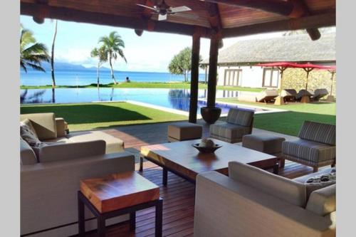 a living room with couches and a view of the ocean at Villa Takali - CFC Certified in Pacific Harbour