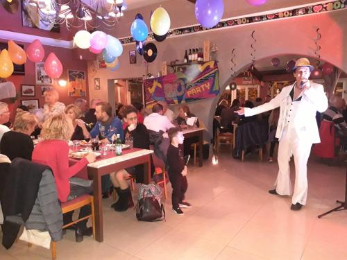 a man standing on a stage in a restaurant at Atoll Hotel restaurant in Fréjus