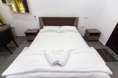 a large white bed with two pillows on it at Dhangethi INN in Dhangethi