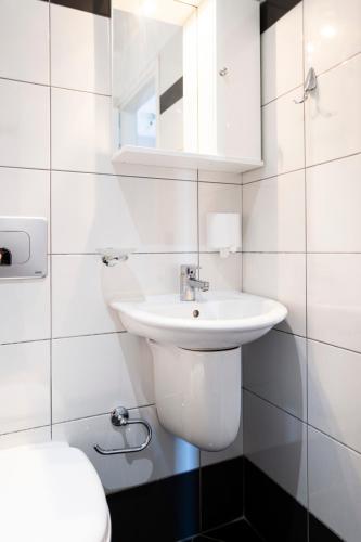 a white bathroom with a sink and a toilet at Margarita Guesthouse in Himare