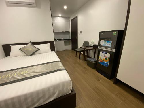 a bedroom with a bed and a desk and a kitchen at The Nova Hotel & Apartment in Hai Phong