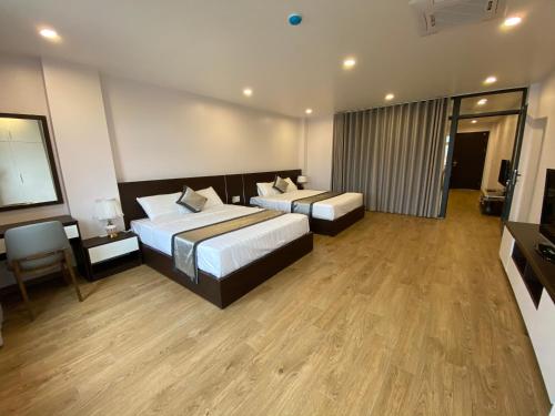 a hotel room with two beds and a television at The Nova Hotel & Apartment in Hai Phong