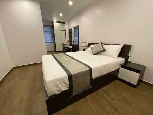 a bedroom with a large bed with white sheets and pillows at The Nova Hotel & Apartment in Hai Phong