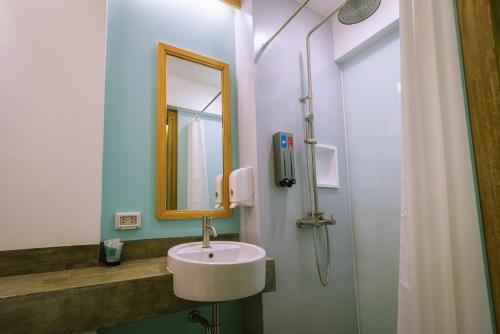 a bathroom with a sink and a mirror and a shower at Lub d Siem Reap - Near Pub Street & Angkor Wat in Siem Reap