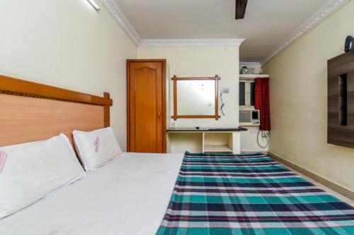 a bedroom with a white bed and a kitchen at Hotel Lakshmi Residency in Visakhapatnam