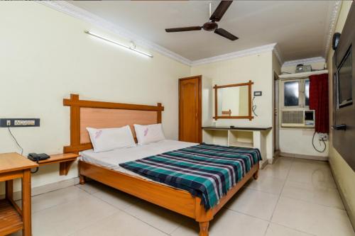 sypialnia z łóżkiem i biurkiem w pokoju w obiekcie Hotel Lakshmi Residency w mieście Visakhapatnam