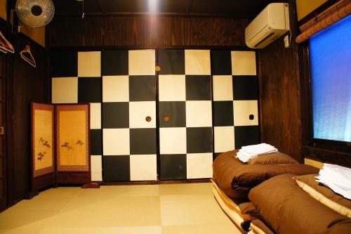 a room with two beds and a checkered wall at Guesthouse Kioto in Kyoto