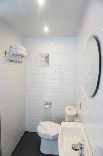 a bathroom with a toilet and a sink and a mirror at Kontena Hotel in Batu