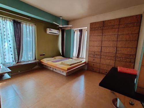 a room with a bed in a room with windows at Garden Homes 1& 6 in Kolhapur