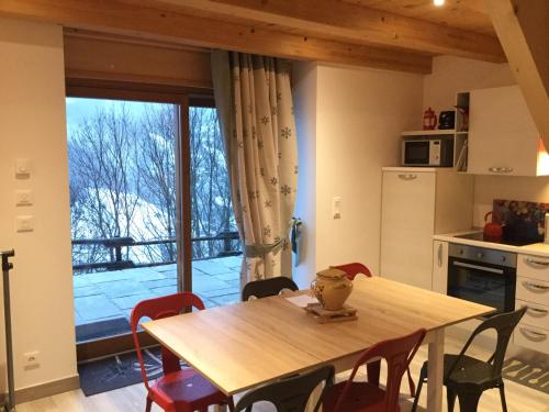 une cuisine avec une table et des chaises ainsi qu'une grande fenêtre dans l'établissement Appartement Le Pontet Areches Beaufort, à Arêches