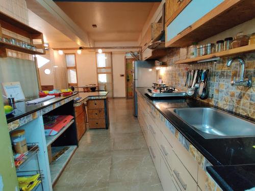 a large kitchen with a sink and a counter top at Garden Homes 1& 6 in Kolhapur