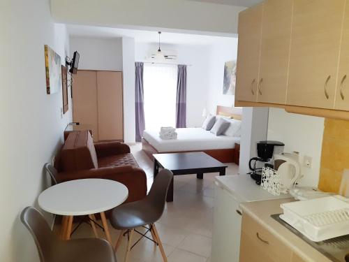 een keuken en een woonkamer met een bed en een tafel bij Olive Tree Apartments in Parga