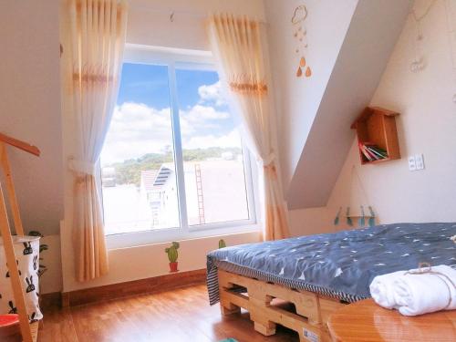 a bedroom with a bed and a large window at Dốc homestay Đà Lạt in Da Lat