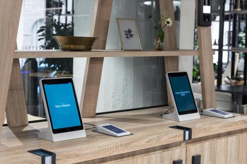 two iphones sitting on a wooden shelf at Noli Sörnäinen in Helsinki