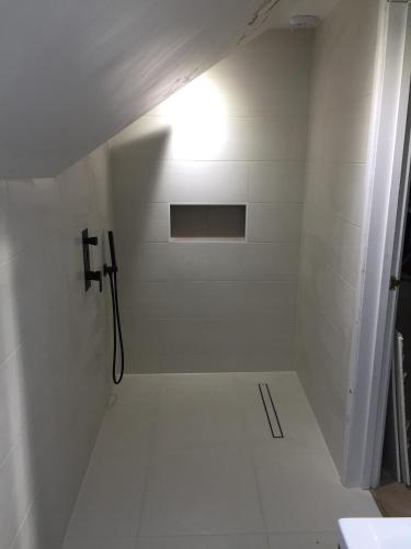 a bathroom with a shower with a light on the wall at Spacious double bedrooms sharing new bathroom, en-suite option available, Kings Lynn in Kings Lynn