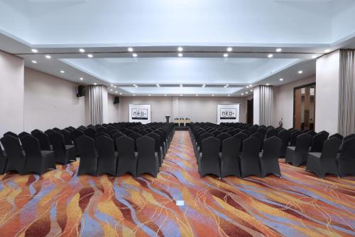 a conference room with black chairs and a carpet at NEO+Waru-Sidoarjo by ASTON in Sidoarjo