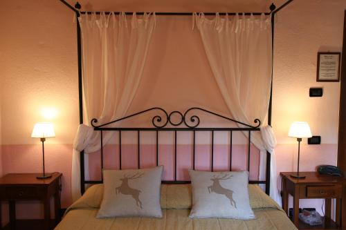 
a bed room with two lamps on top of it at Molino Di Foci in San Gimignano
