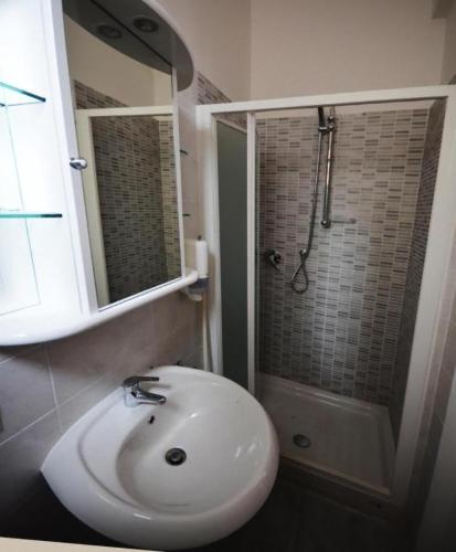 a white bathroom with a sink and a shower at Tourist House Bologna - Self check-in in Bologna