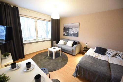 uma sala de estar com uma cama e um sofá em Rental Apartment Kupittaa Suomen Vuokramajoitus Oy em Turku