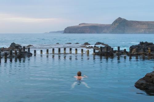 a person swimming in a body of water at Casa Calma Yoga Guesthouse in Agaete