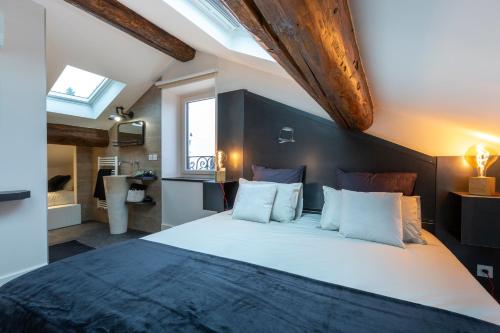 a bedroom with a large bed and a bathroom at L'Enclos de Ribains in Aubière