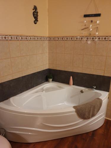 a white tub in a bathroom with a tiled wall at B&B Mirage in Frécourt
