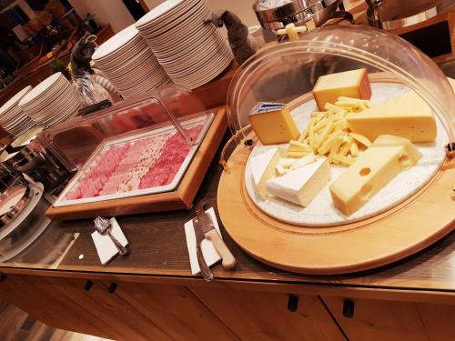 a table with different types of cheeses and meats at Hotel Europa Guest House in Saas-Fee