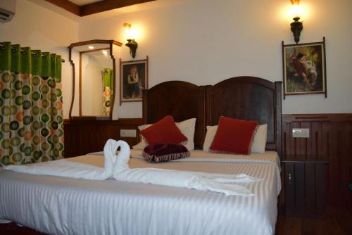 - un lit avec un cygne fait de serviettes dans l'établissement Mango Kerala Homes, à Kumarakom
