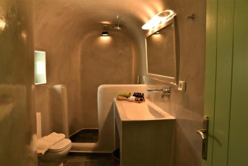 a bathroom with a sink and a toilet and a mirror at Morning Star Traditional Houses in Pyrgos