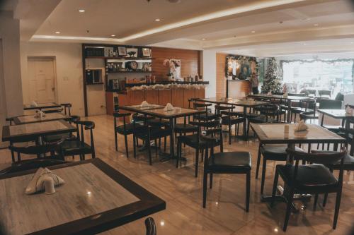 a restaurant with tables and chairs in a room at NS Royal Hotel in Cebu City