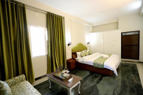 a bedroom with a bed and a couch and a table at The Q Villa, Udaipur in Udaipur