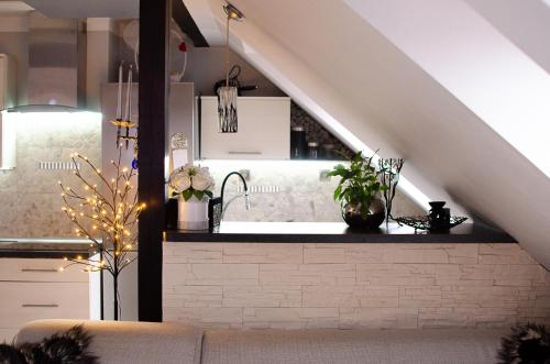 a living room with a kitchen under the stairs at Apartament CENTRUM in Mrągowo