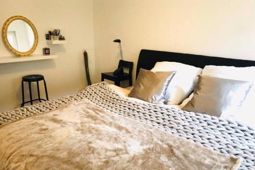 a bedroom with a bed with white pillows and a mirror at Your beautiful Homestay in Rheinfelden