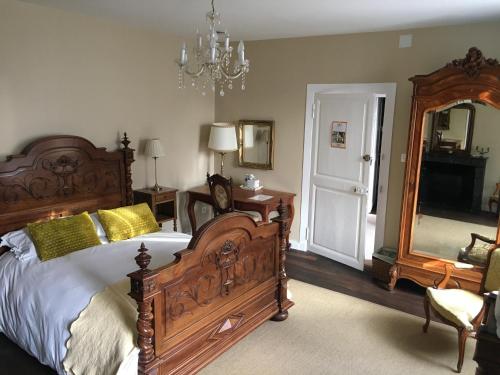 1 dormitorio con 1 cama grande y espejo grande en La Ruche Bed & Breakfast, Chaillac, en Chaillac