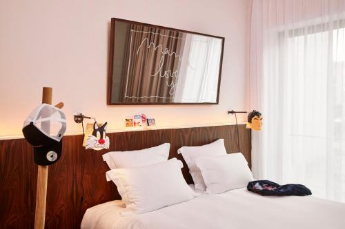 a bedroom with two beds and a picture on the wall at Mama Shelter Luxembourg in Luxembourg