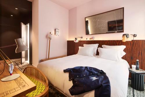 a hotel room with a large bed and a table at Mama Shelter Luxembourg in Luxembourg