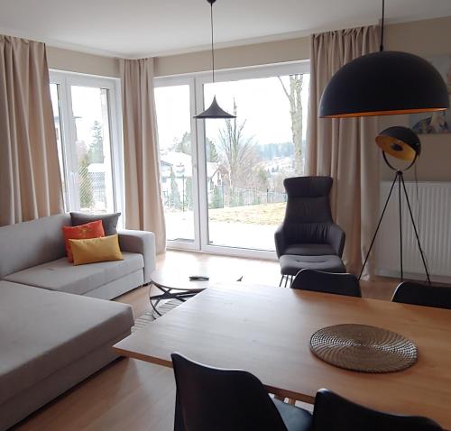 ein Wohnzimmer mit einem Sofa und einem Tisch in der Unterkunft Apartamenty EverySky - Izerska 8 in Szklarska Poręba