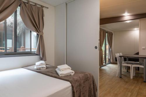 a bedroom with a bed with towels on top of it at Camping Village Santapomata in Castiglione della Pescaia