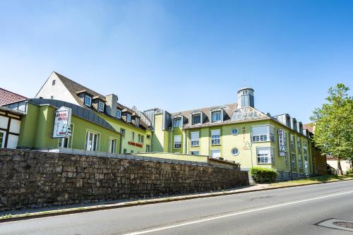 a row of green and yellow buildings on a street at Hotel Tanne in Saalfeld