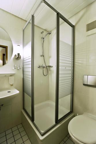 a bathroom with a shower and a toilet and a sink at Kleefelder Hof in Hannover