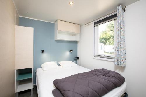 une chambre avec un lit et une fenêtre dans l'établissement Camping La Belle Etoile, à Melun
