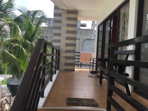 a balcony of a house with a staircase and palm trees at Casa Herminia Baler in Baler